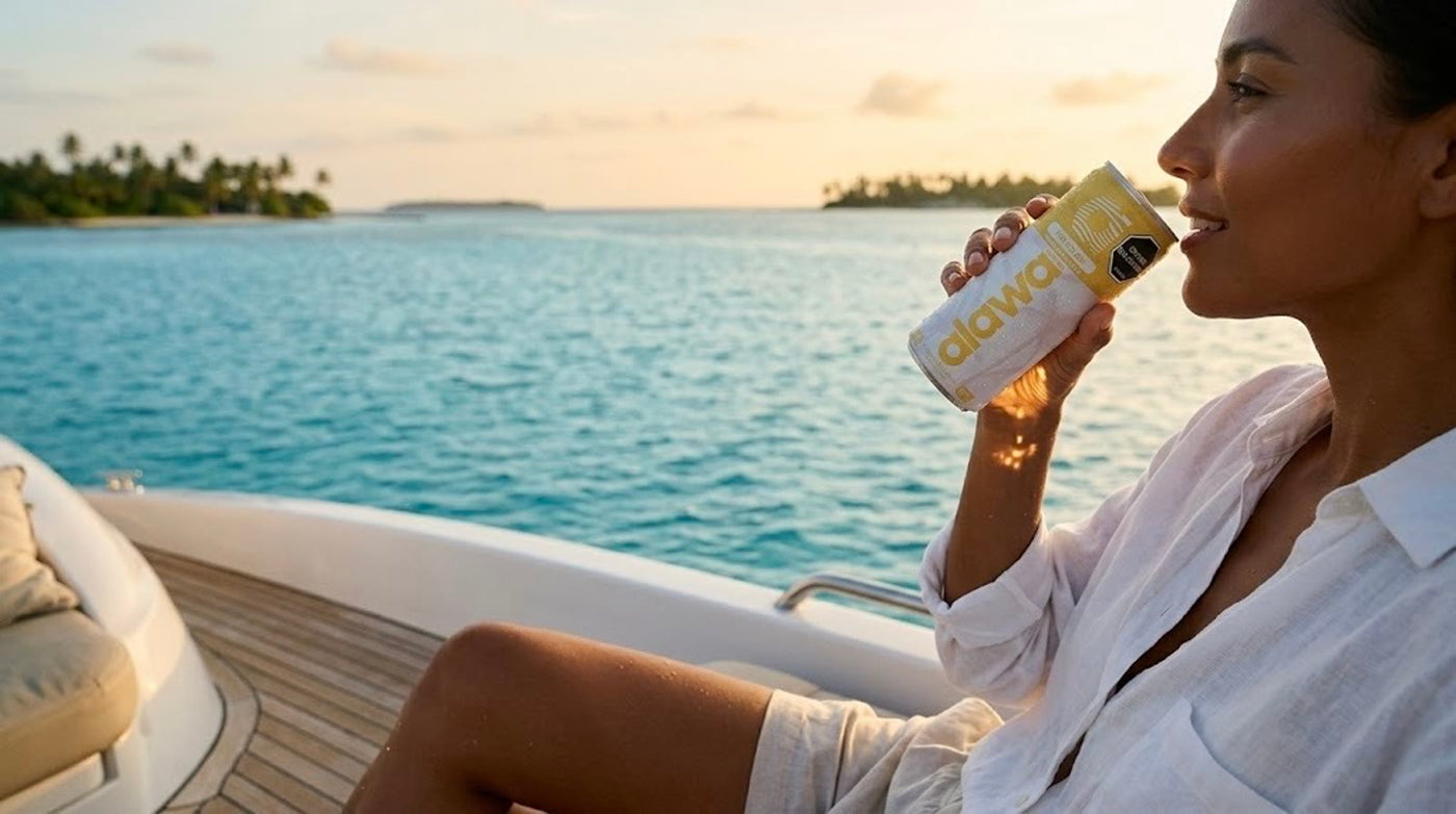 Un pedazo de playa en cada sorbo — mujer disfrutando una Alawa Piña Colada en un yate al atardecer